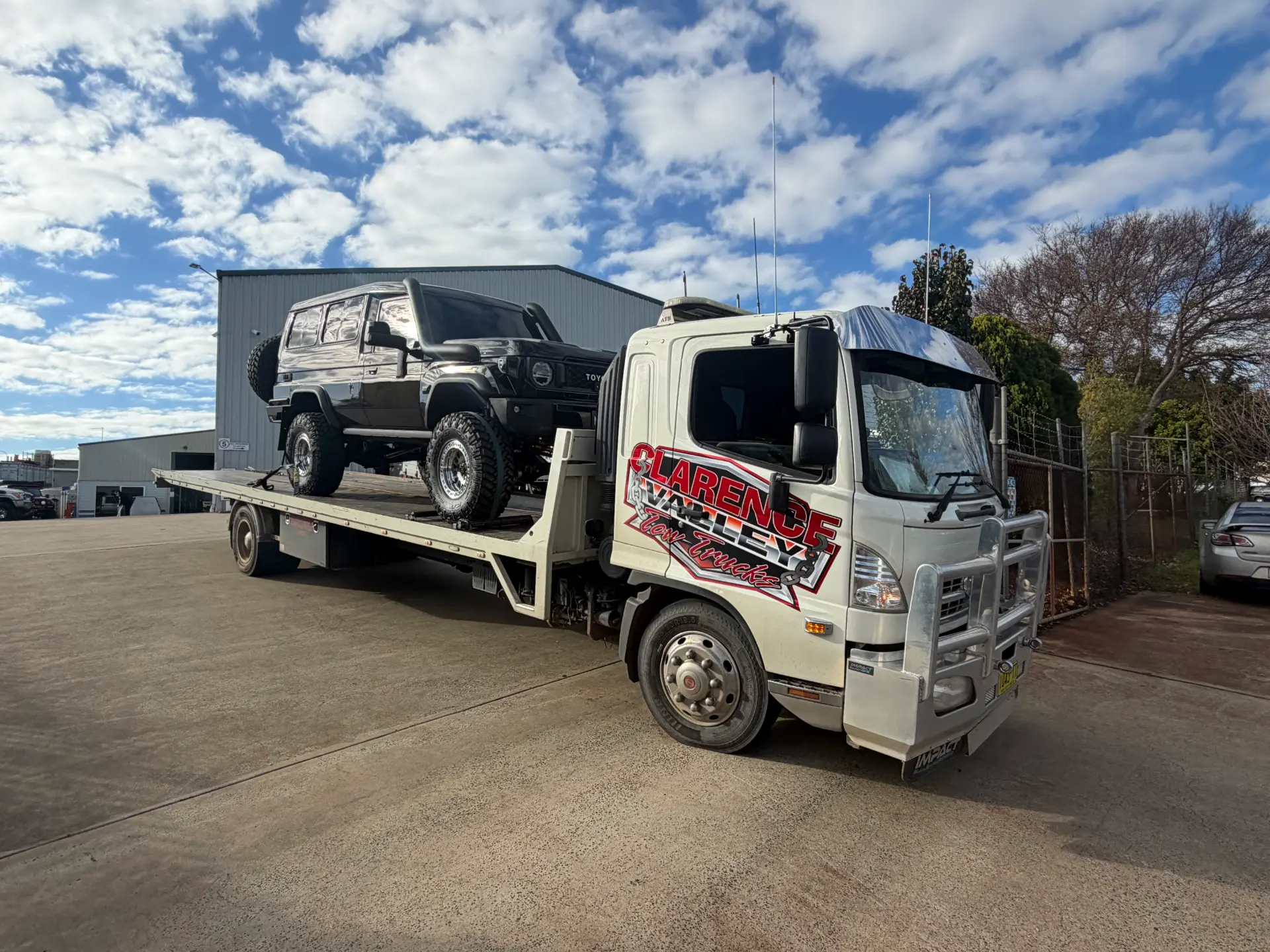 A four-wheel drive loaded on a Clarence Valley Tow Trucks tilt tray